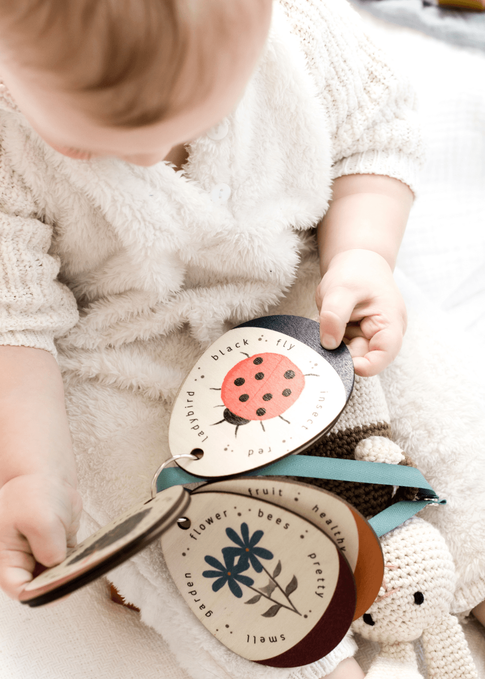 Baby gifting with a toddler enjoying wooden stroller cards, featuring colourful illustrations and engaging designs.