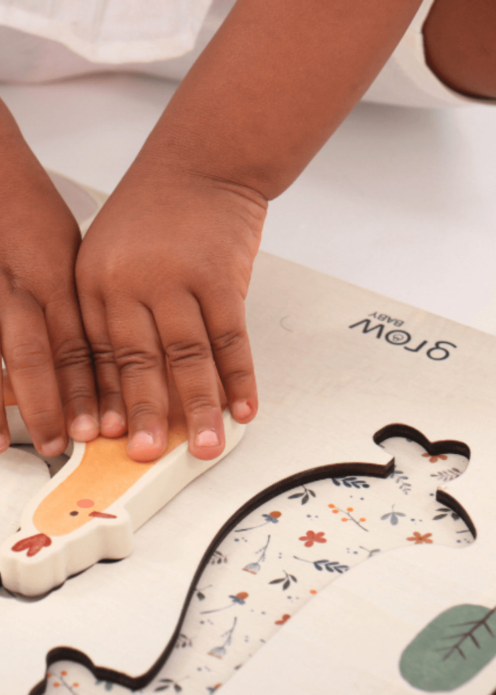 Child's hands placing a chunky piece of a Wooden Puzzle into the country-themed board for educational play.