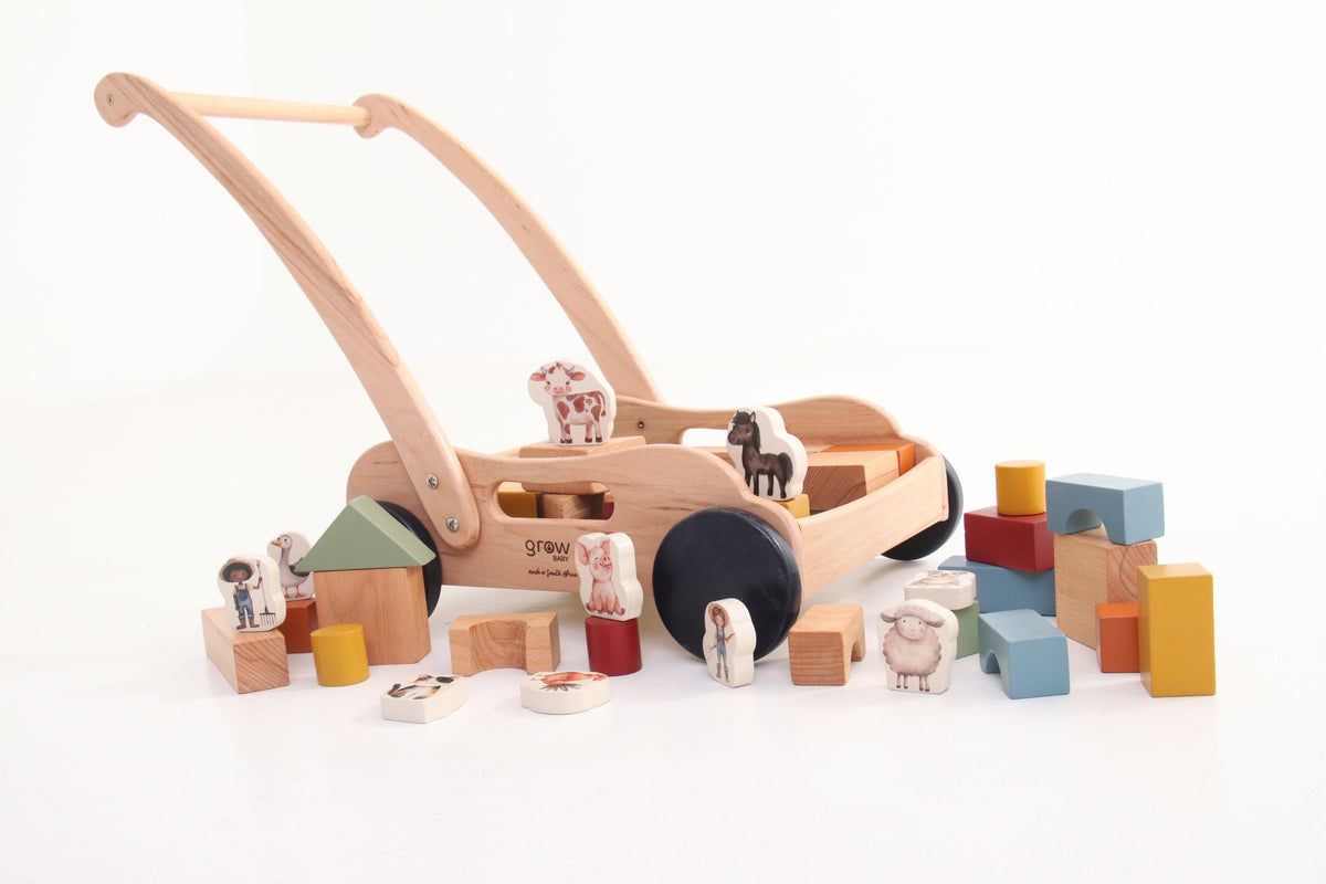 Toddler playing with wooden toys while wearing a floral dress from the Bebe Pure Collection.