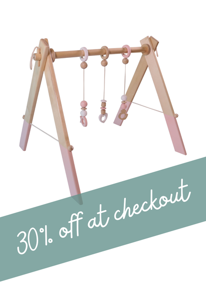 Wooden baby gym in pastel pink with 30% off at checkout