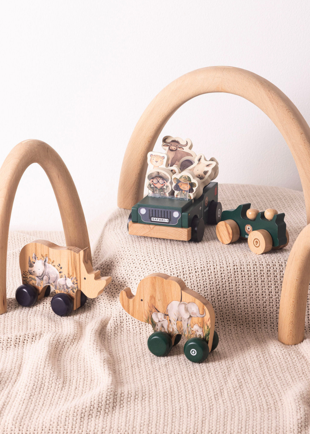 Wooden Toy Set featuring Jeep and Rhino push cars arranged in a safari scene on a textured blanket.