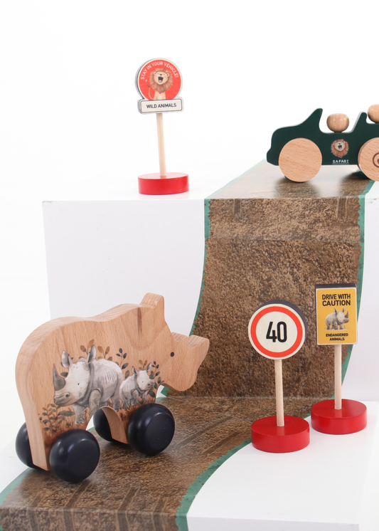 Wooden push cars, road signs, and a wooden rhino toy in a playful setup, ideal for imaginative play.