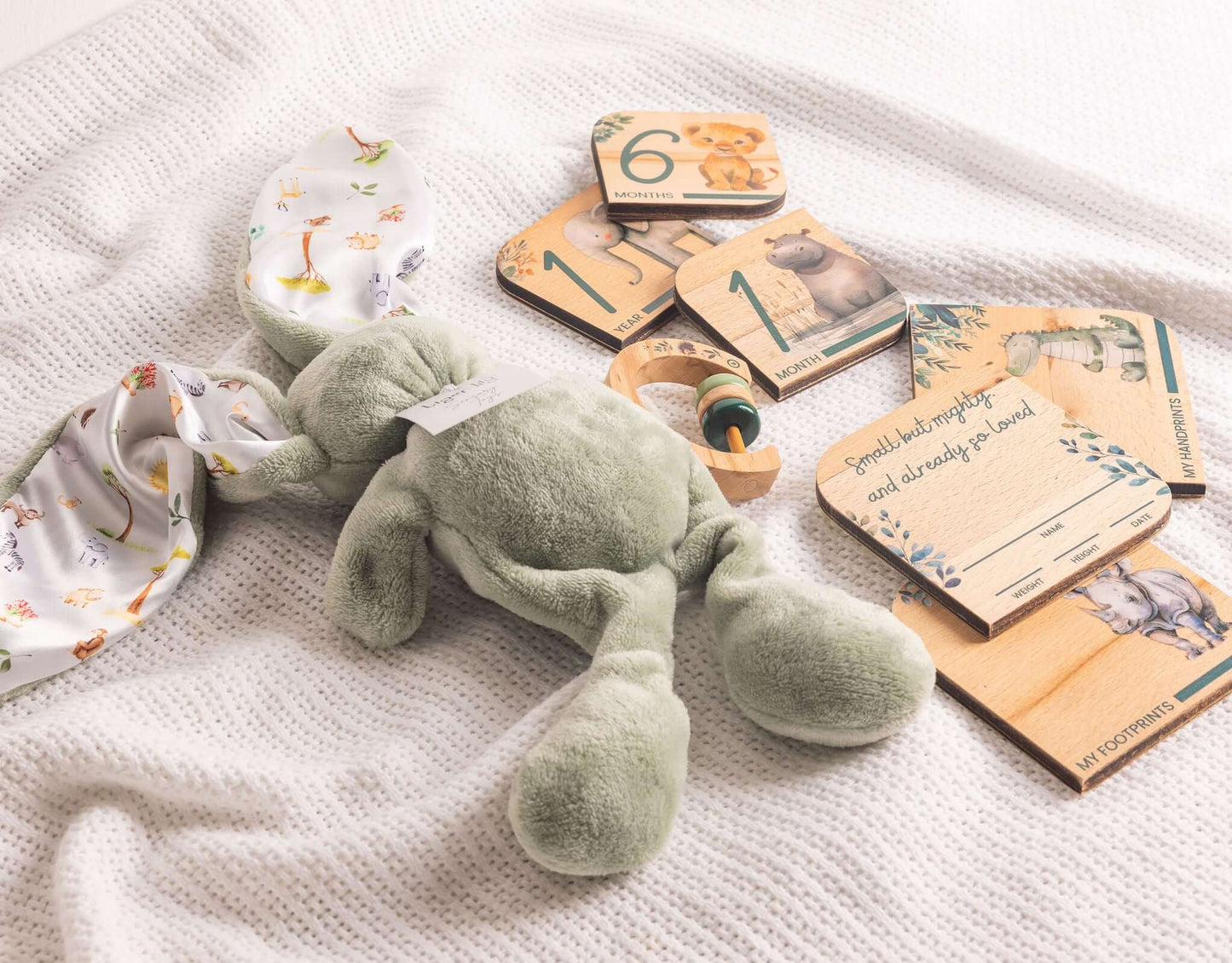 Baby Gift Set featuring a soft bunny, milestone disks, and wooden rattle on a cozy blanket.
