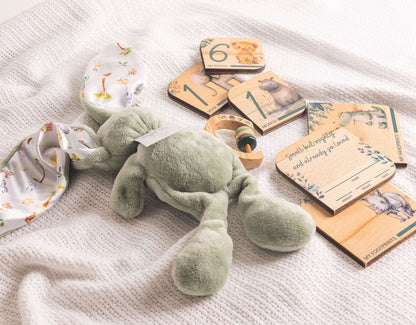 Baby Gift Set featuring a soft bunny, milestone disks, and wooden rattle on a cozy blanket.