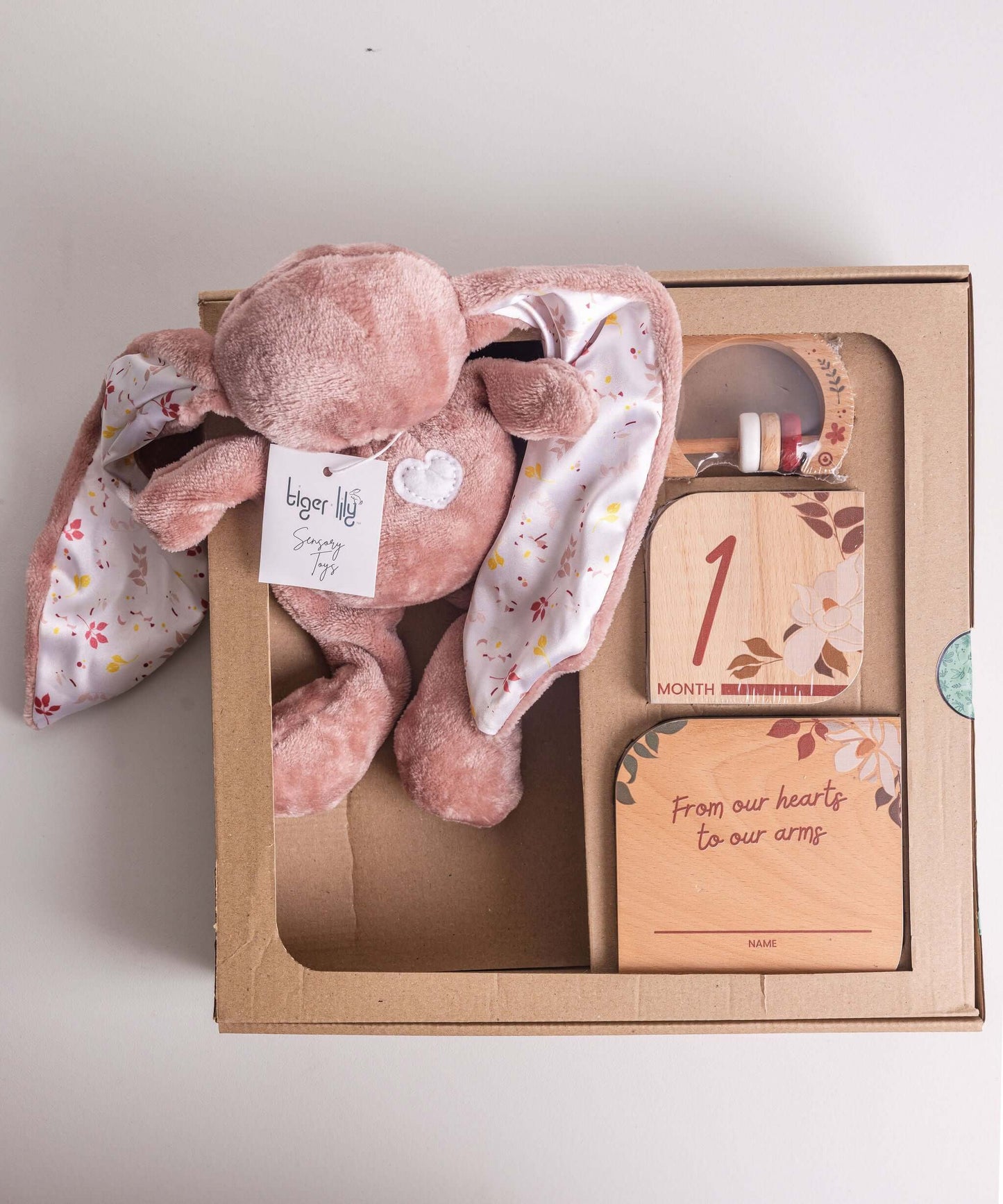 Baby gift set featuring Tiger Lily Bunny, milestone disks, and rattle in a gift box.