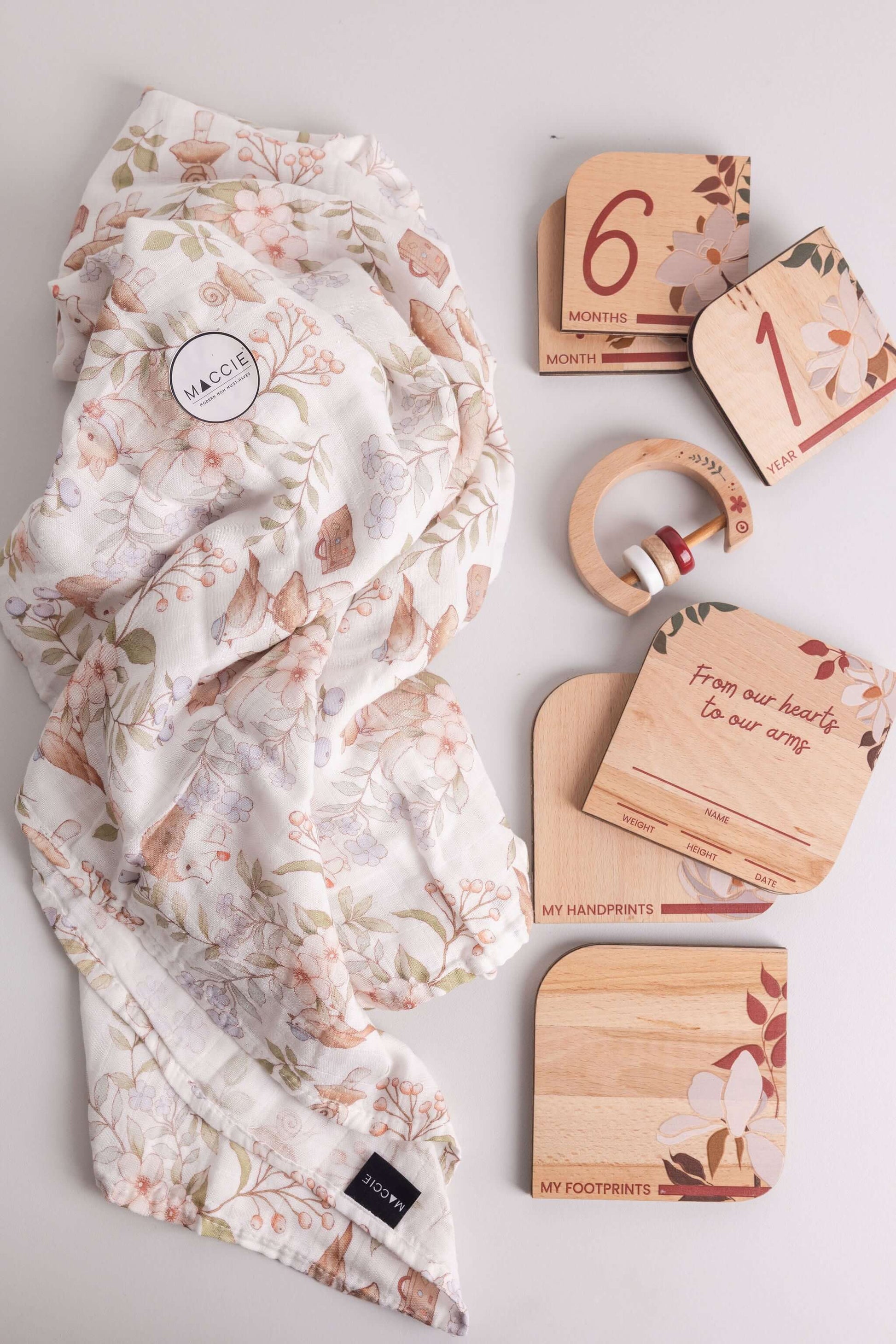 Baby Gift Set featuring Maccie Swaddle, milestone disks, wooden rattle, and crafted designs.