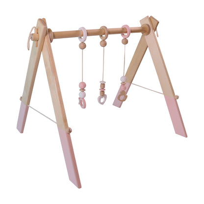 Wooden baby gym in pastel pink design with hanging toys for infants